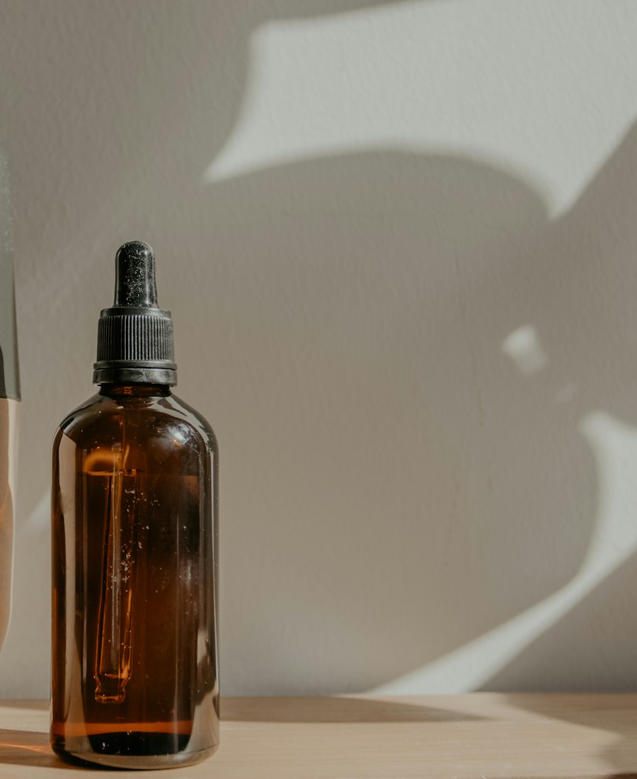 Amber dropper bottle of Monsoon Serum on a wooden shelf, palm shadows across the wall behind